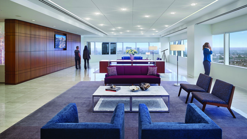 A room with a couch and chairs.