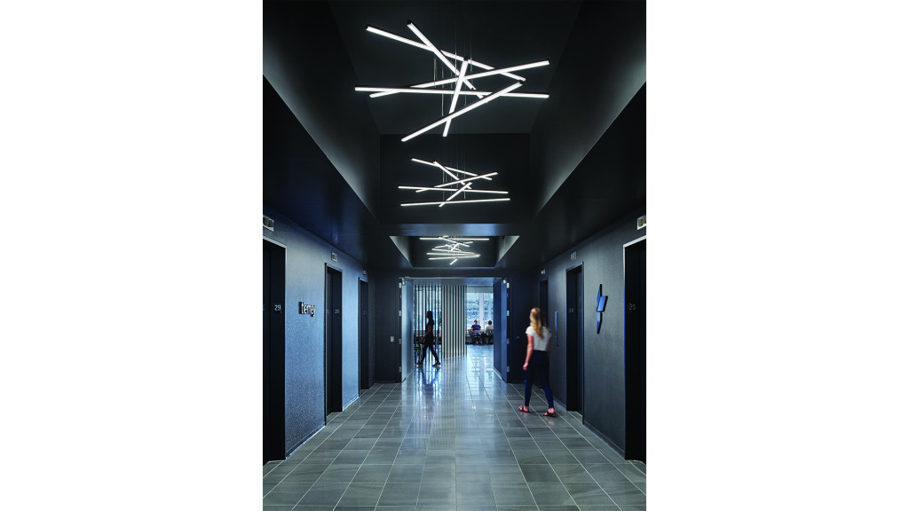 A couple of women walking through a hallway.