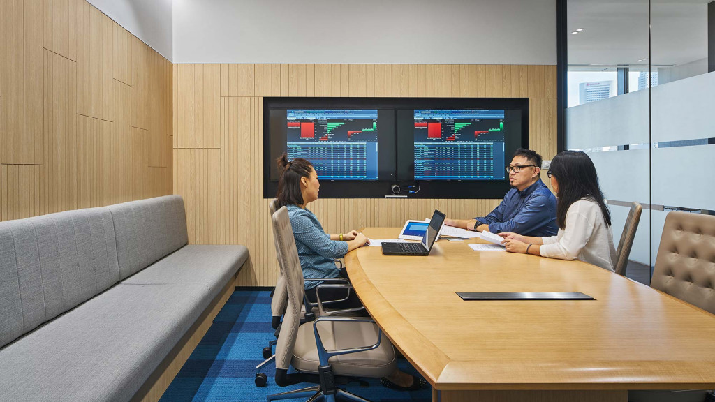 A group of people sitting around a table with a laptop.