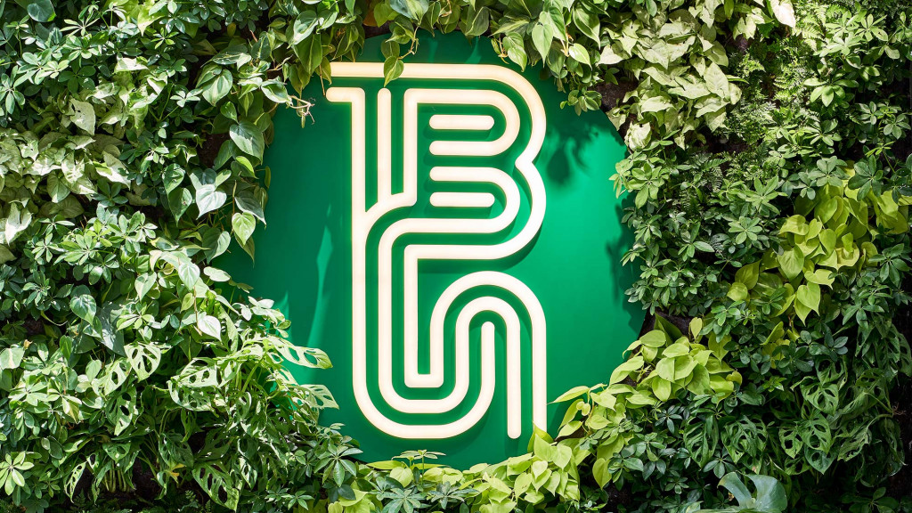 A green sign on a bush.