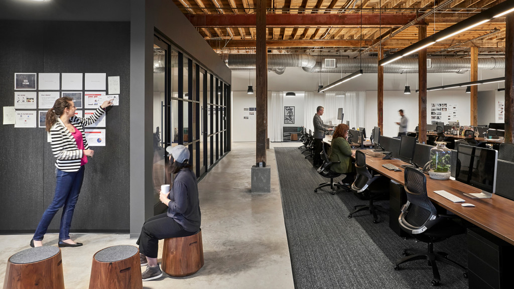 A person standing in a room with people sitting at desks.