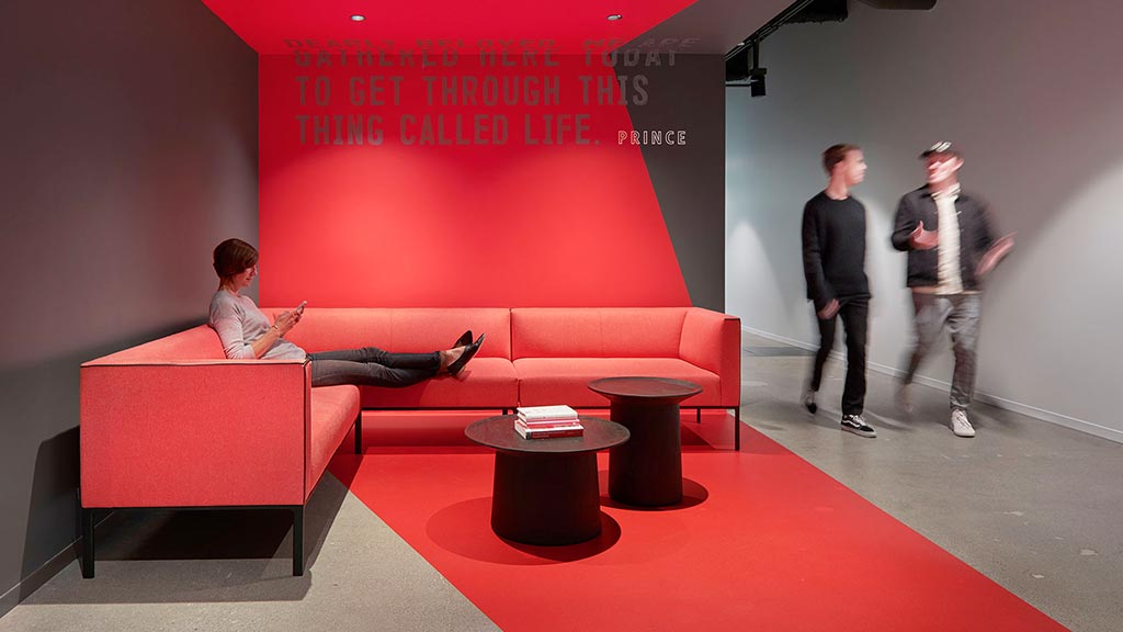 A man sitting on a red couch.