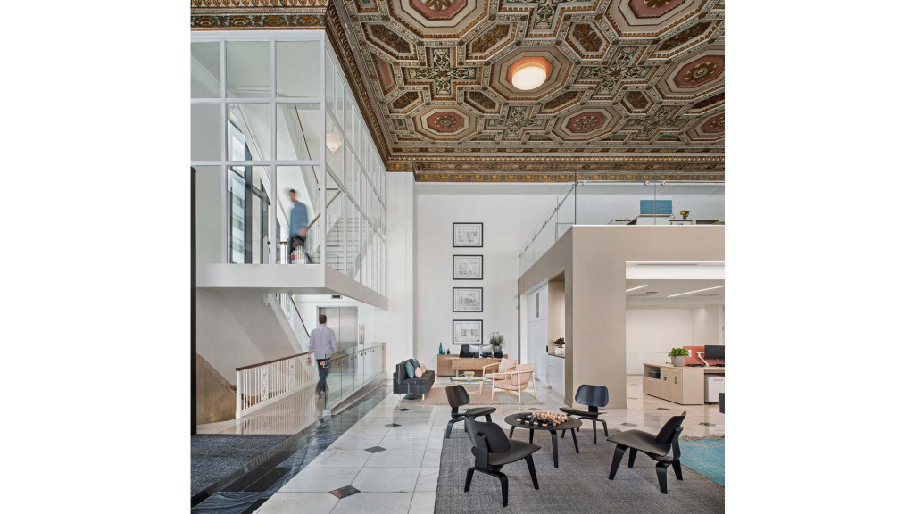 A room with tables chairs and people.