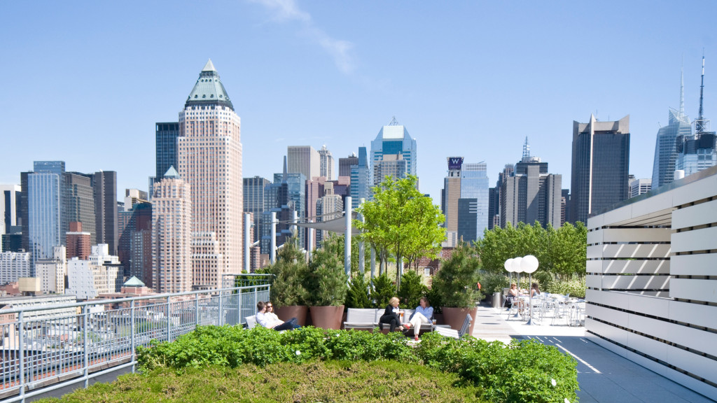 A city skyline with a park and a river.