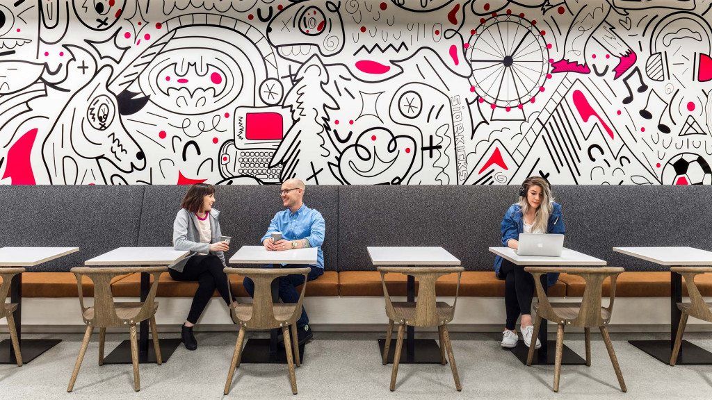 A group of people sitting at a table with laptops.