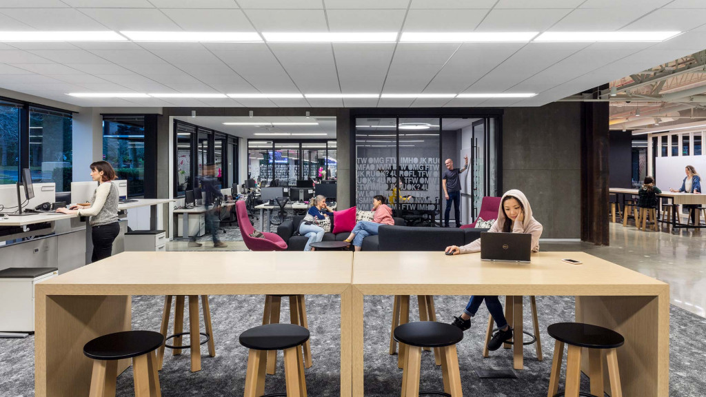 A group of people sitting at a table with a laptop.
