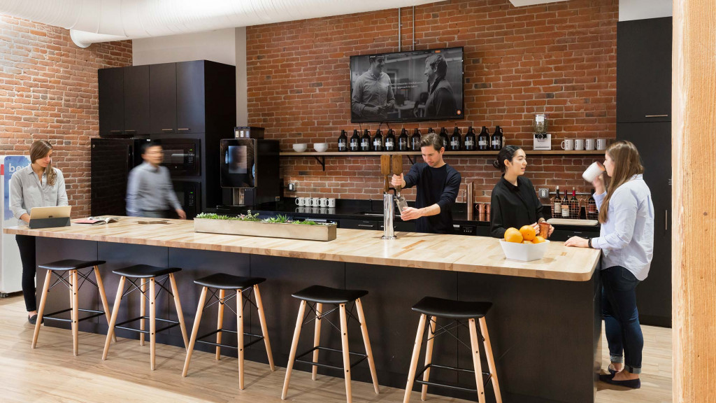 A group of people standing around a bar.