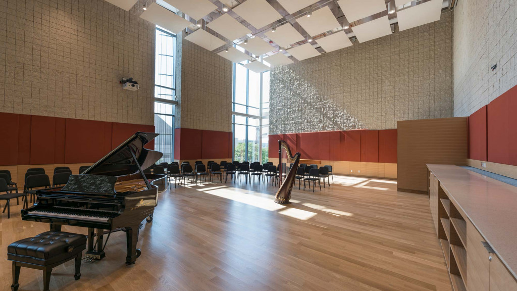 A large room with a piano and chairs.