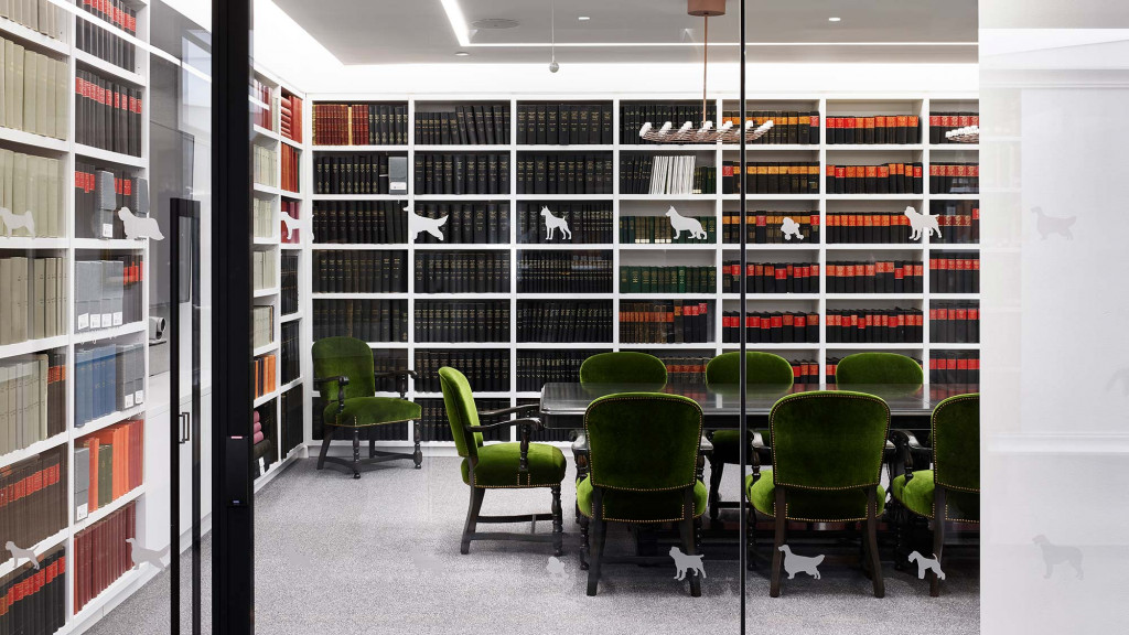 A room with green chairs and shelves.