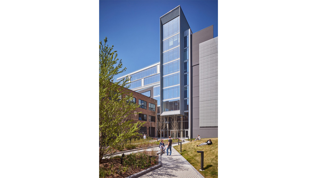A building with a walkway and grass.