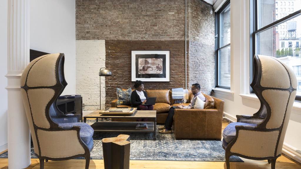 A couple of women sitting on a couch in a living room.