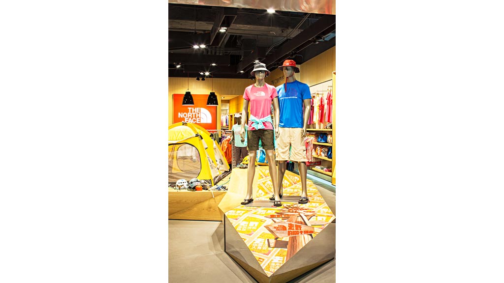 A couple of men standing on a model of a car.