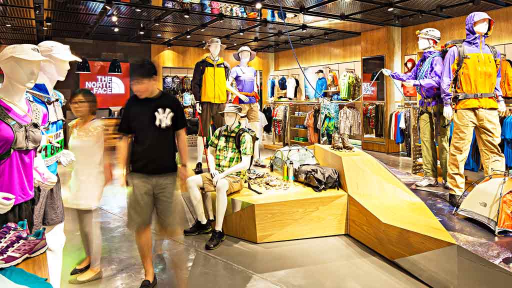 A person standing next to a display of stuffed animals.