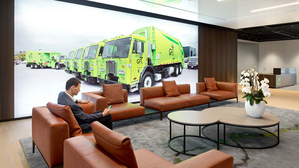 A person sitting on a couch in a room with a yellow truck.