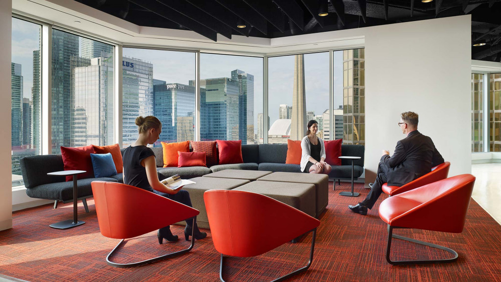 A group of people sitting in a room with a large window.