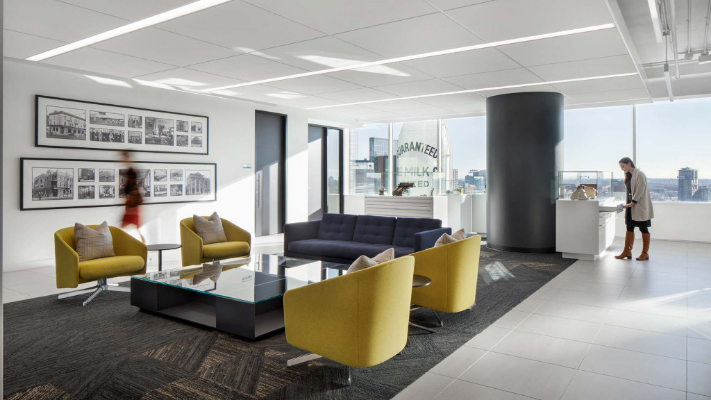 A person standing in a room with a large window and a couch.