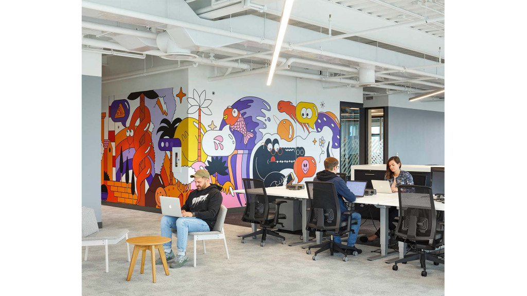 A group of people sitting at a table with computers.