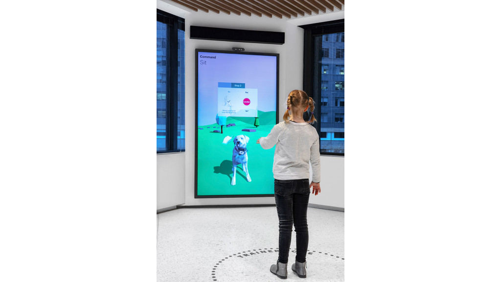 A woman standing in front of a large screen.