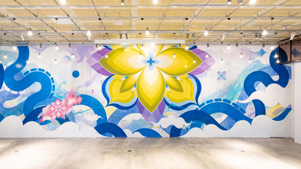A wall with a mural of a flower and a butterfly.