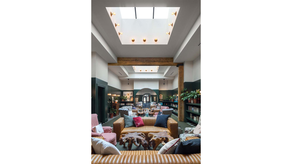 A room with a couch and chairs.