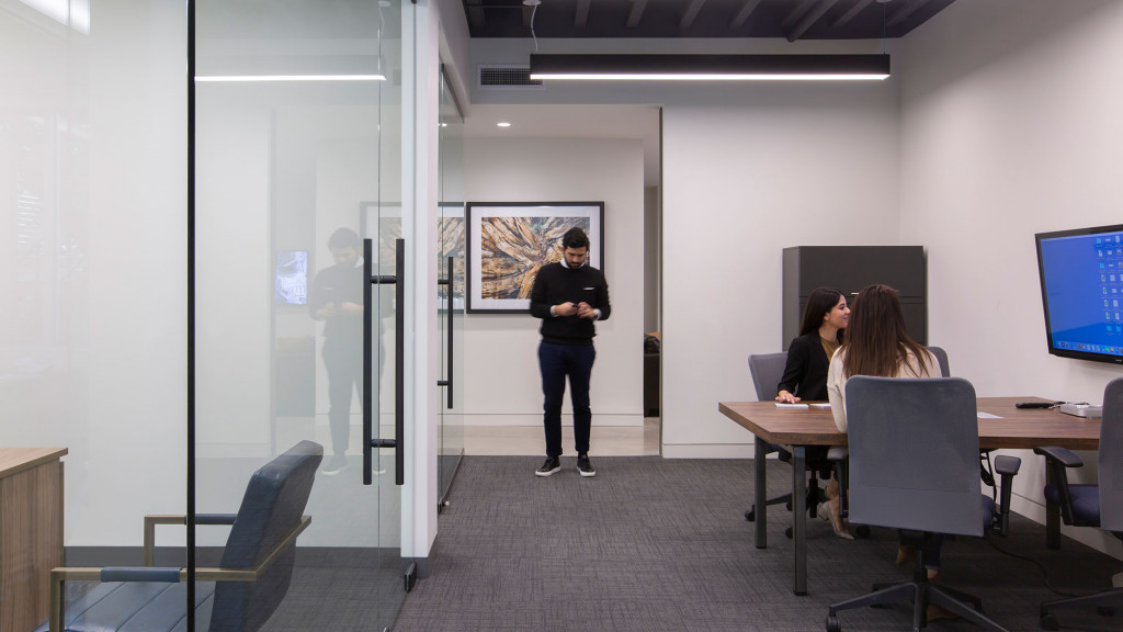 A person standing in a room with people sitting at desks.