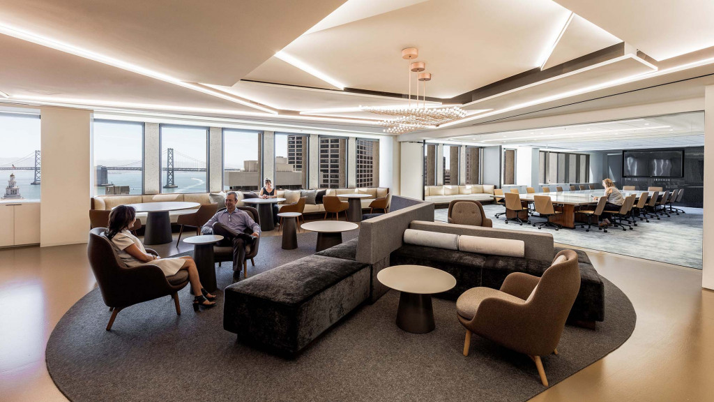 A group of people sitting in a room with a large window.