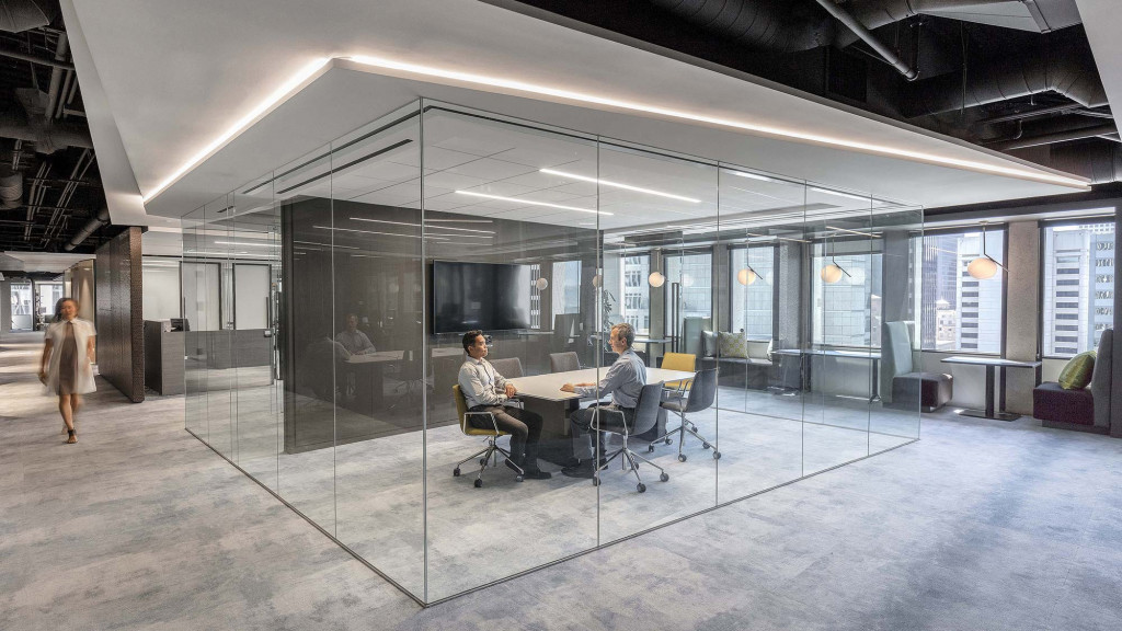 A group of people sitting at a table in a large room.