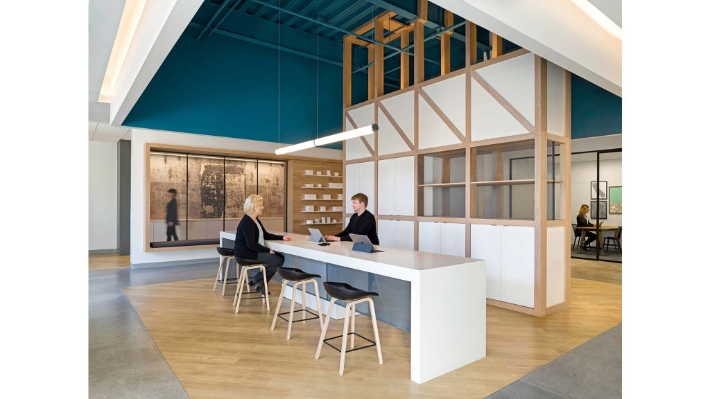 A man and a woman sitting at a table in a room with a large glass wall.