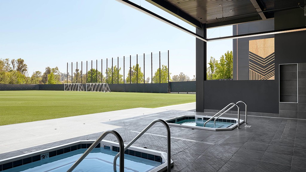 A swimming pool with a grass field.