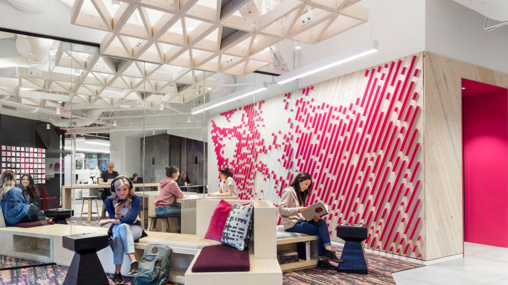 A group of people sitting in a room with a red wall.