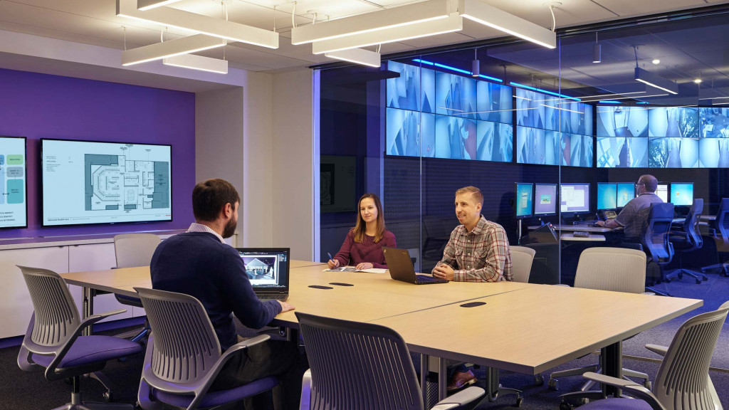 A group of people sitting at a table with computers.