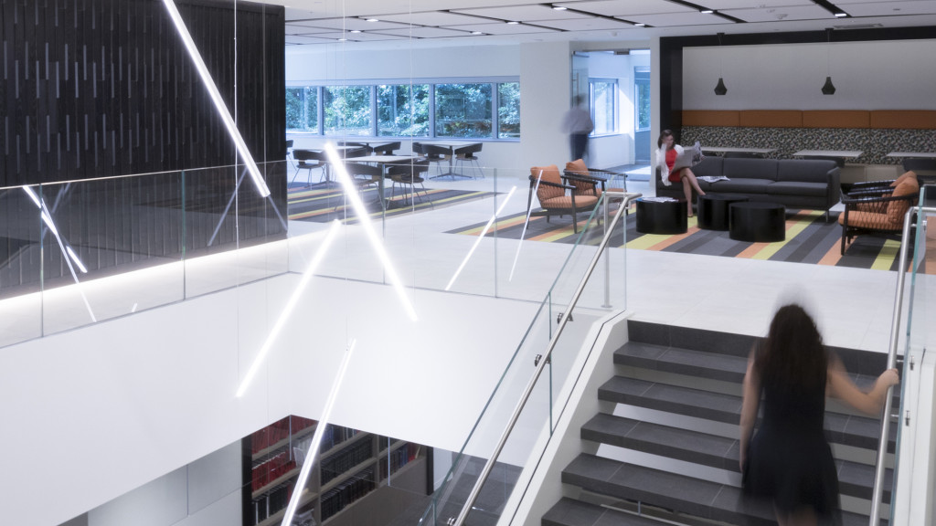 A room with a staircase and people.