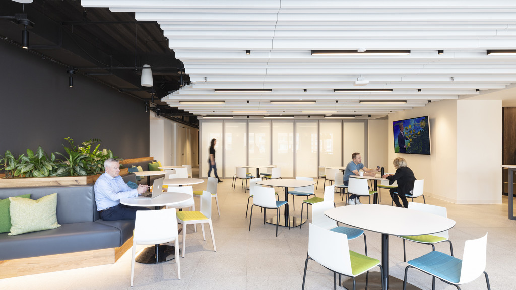 A group of people sitting in a room with tables and chairs.