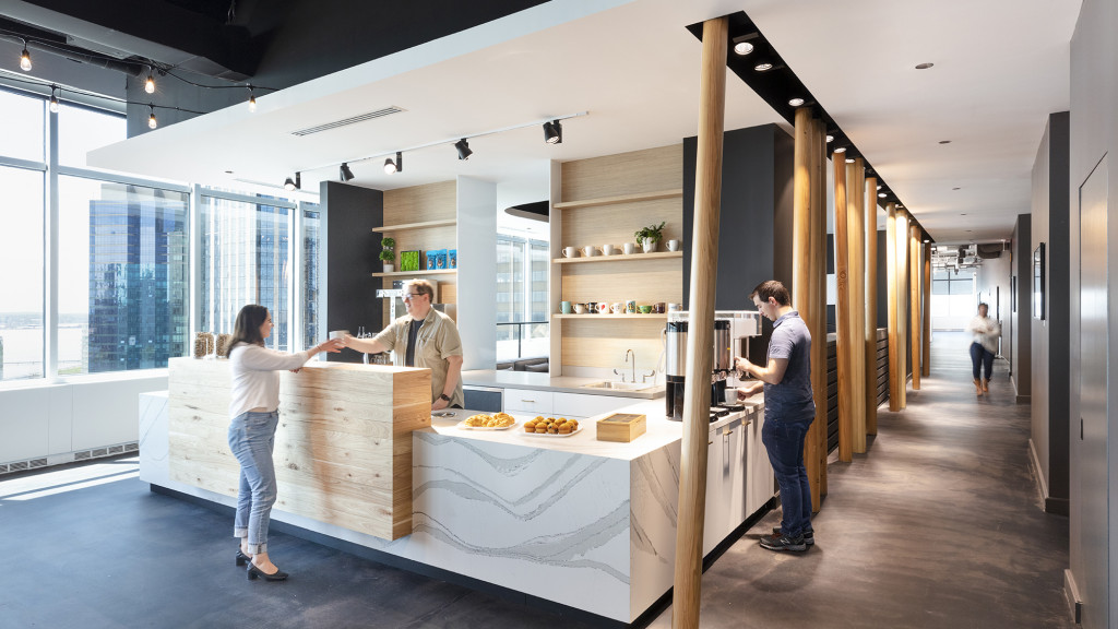 People in a room with a table and shelves with food on it.