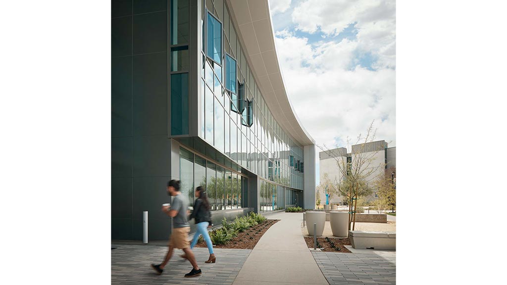 A man and woman walking outside of a building.