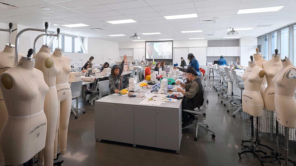 A group of people in a room with large white sculptures.