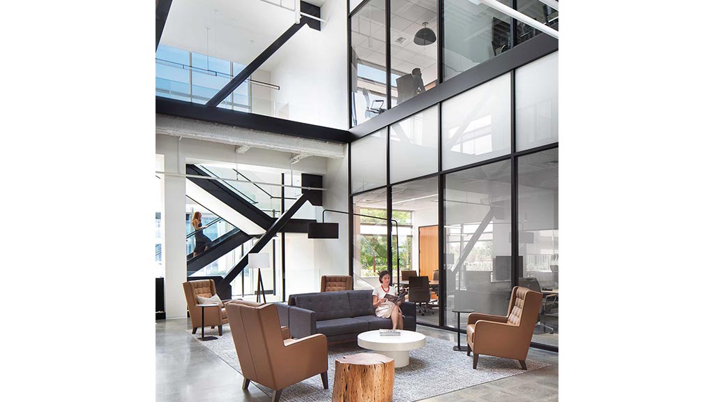 A person sitting in a chair in a room with a large glass wall.