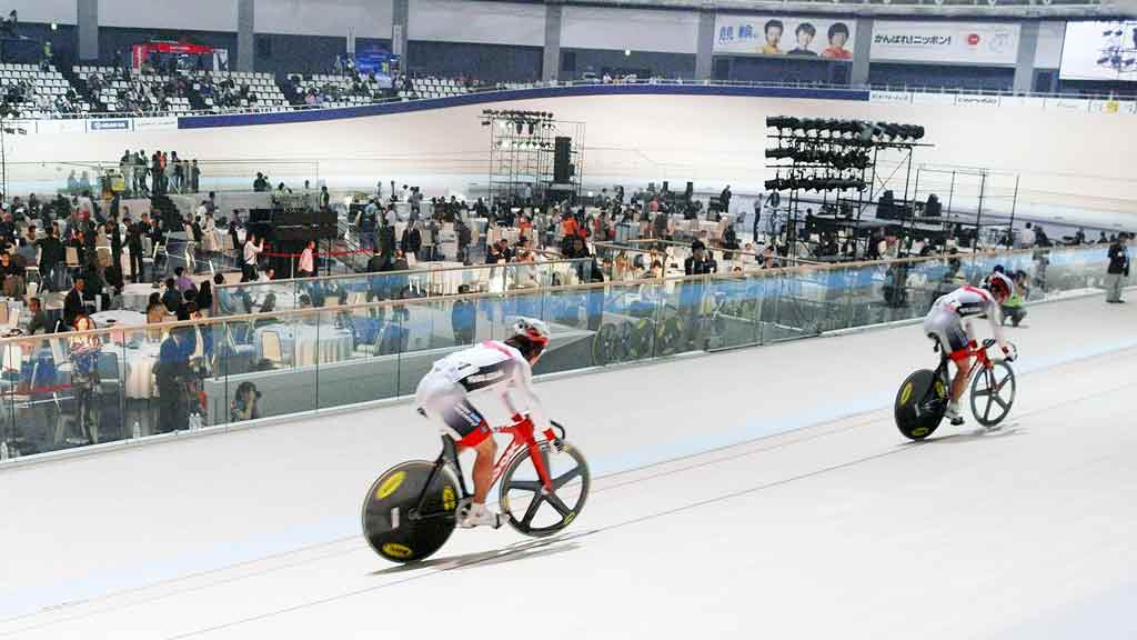 A group of people riding bikes on a track.