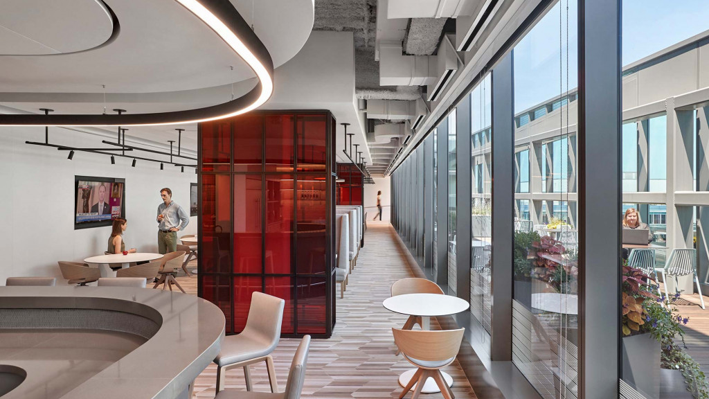 A room with a glass wall and a table and chairs.