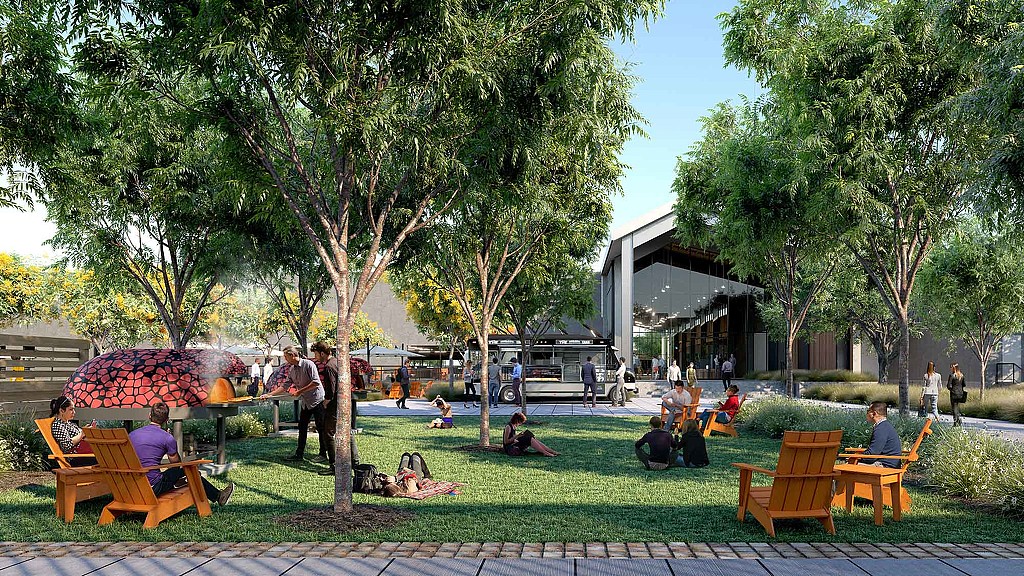 A group of people sitting on a bench in a park.