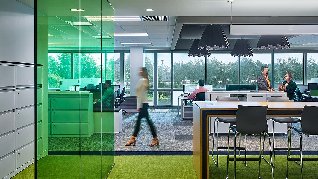 A person walking in a large office.