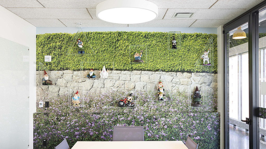 A room with a stone wall and a large garden of flowers.