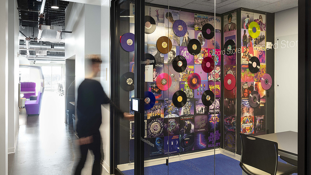 A person walking in a room with many colorful buttons.