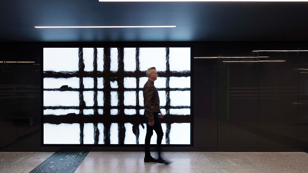 A person standing in front of a window.