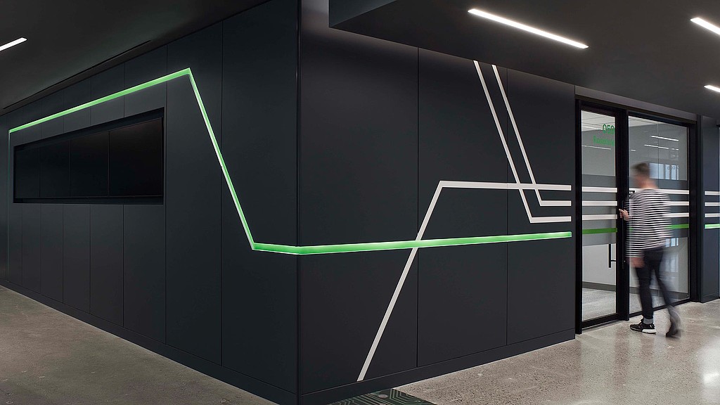 A person standing in a room with a large black wall.