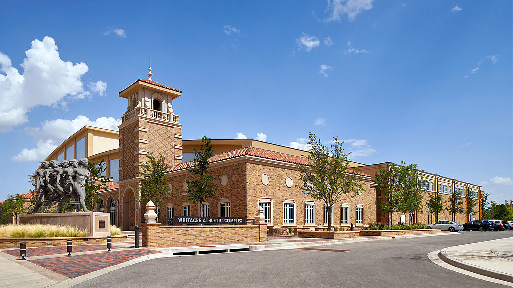 A large brick building with a statue in front of it.
