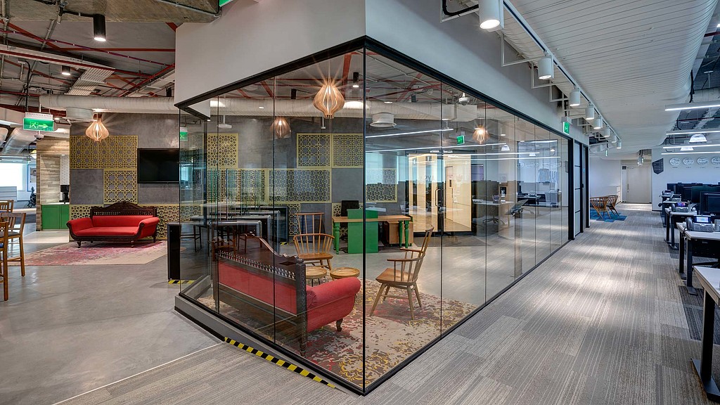 A room with glass walls and a red couch.