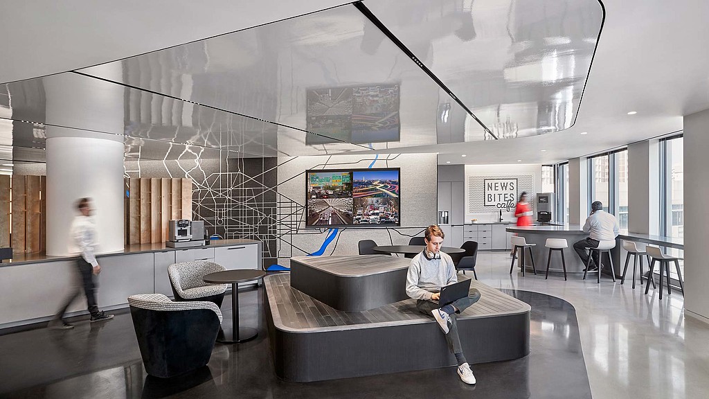 A group of people in a room with large screens.