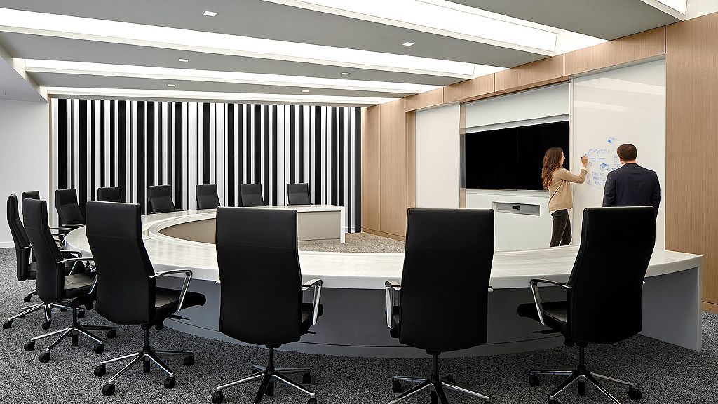 A room with a large screen and chairs.