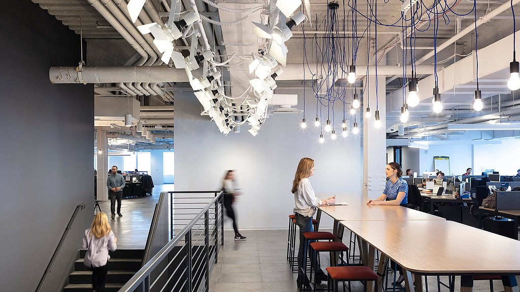 People in a room with tables and chairs.